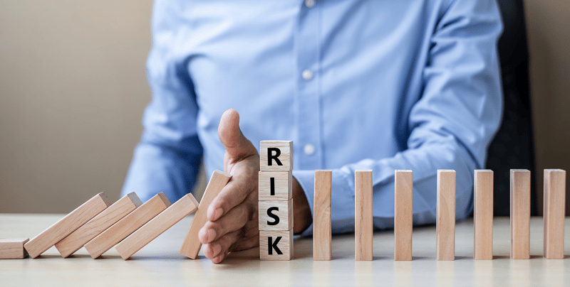 1099-businessman-hand-stopping-falling-wooden-blocks-dominoes-risk-1197x605